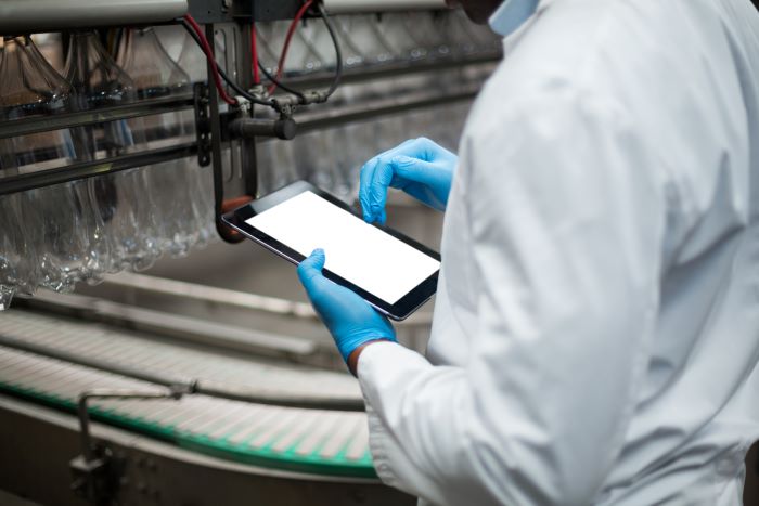 Trabajador en una fábrica utiliza una tablet.